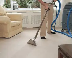 Carpet cleaning professional removing dirt and stains with a hot-water extraction tool in a home, Marietta, GA.