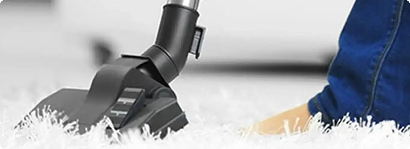 Close-up of a professional vacuuming a white carpet in Kennesaw.