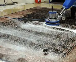 Professional rug cleaning with a rotary floor machine and shampoo foam, deep-cleaning an area rug, in Marietta, GA.